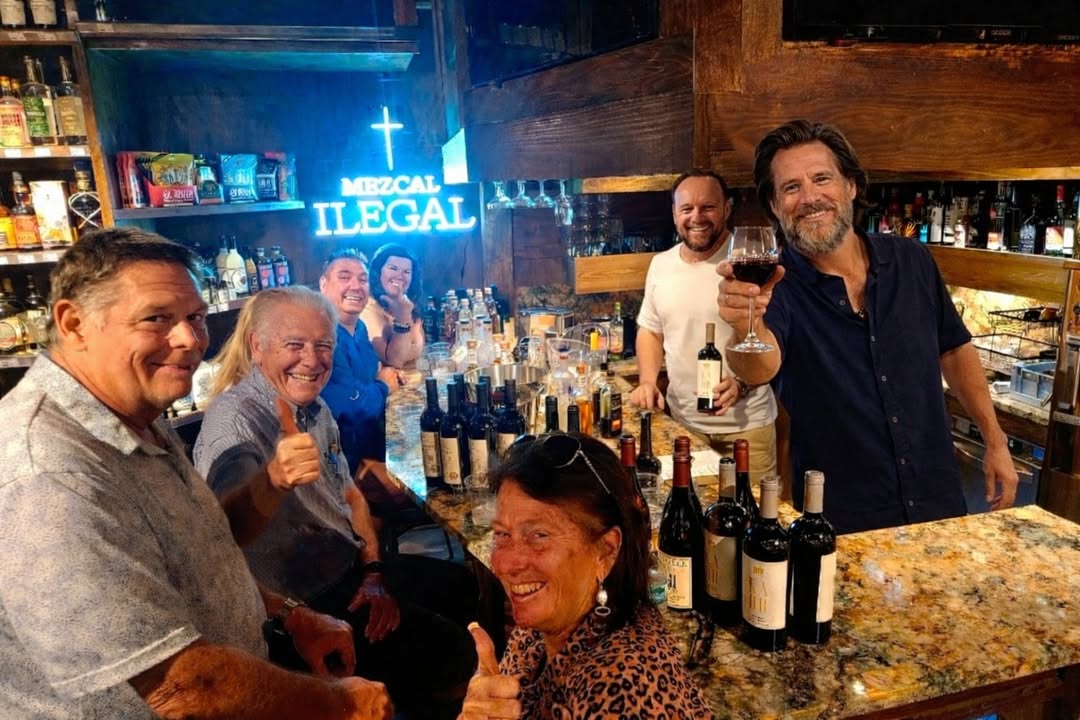 The tasting bar at Primo Liquors in Broward County, Florida, with customers and the spirits wall behind